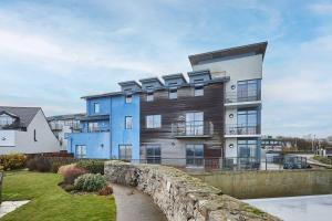 a blue and white building with a stone wall at Host & Stay - The Shipshape in Seahouses