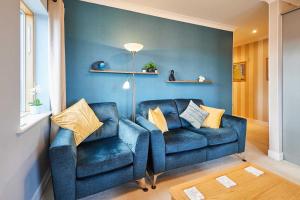 a blue couch and a chair in a living room at Host & Stay - The Shipshape in Seahouses +18 photos