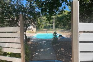 a fence in front of a swimming pool at Gîte du Jonquas in Velleron