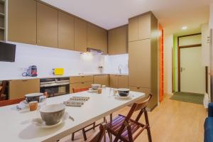 a kitchen with a white table with chairs and a counter at L HELIOS Centre ville 1 chambre in Cauterets +4 photos