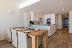 a kitchen and dining room with a wooden table and chairs at BEL AIR HOLIDAY - Luxury 2-bedroom apartment with sea view & jacuzzi T48 in Ostend