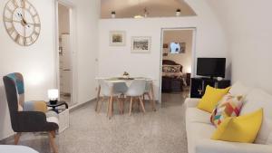 a living room with a white couch and a table at B&B Sotto l'Arco nel Cuore del Centro Storico in Gravina in Puglia
