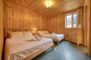 a bedroom with two beds in a wooden cabin at Chalet Ours 7 min to SPA for 16 Guests, Skiing in Saint-Paul-de-Montminy
