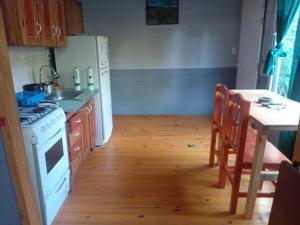 een keuken met een wit fornuis top oven naast een tafel bij Soleada delta in Estación Delta +6 foto's