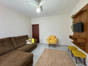 a living room with a couch and a chair at Casa completa, ar e vaga, perto parque Ecológico in Ourinhos