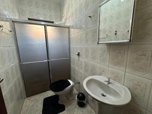 a bathroom with a sink and a toilet and a shower at Casa completa, ar e vaga, perto parque Ecológico in Ourinhos +23 photos
