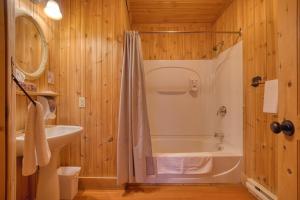 a bathroom with a tub and a sink at Chalet Ours 7 min to SPA for 16 Guests, Skiing in Saint-Paul-de-Montminy