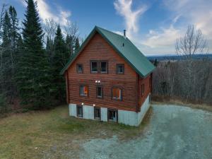 a large wooden house sitting on top of water at Chalet Ours 7 min to SPA for 16 Guests, Skiing in Saint-Paul-de-Montminy