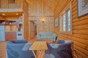 a living room with a table and chairs in a cabin at Chalet Ours 7 min to SPA for 16 Guests, Skiing in Saint-Paul-de-Montminy
