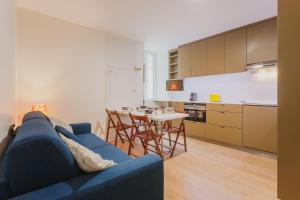 a living room with a blue couch and a table at L HELIOS Centre ville 1 chambre in Cauterets