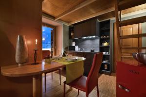 eine Küche mit einem Holztisch und einem Esszimmer in der Unterkunft Cronox Mini Apartments in Livigno + 47 Fotos