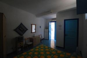 a bedroom with a bed and a desk and a door at Zenzero canneto beach lipari in Canneto - Lipari