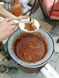 a person holding a plate of food in a pan at Sljivik in Niš