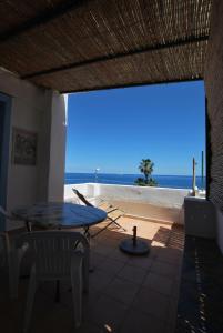 a patio with a table and a view of the ocean at Zenzero canneto beach lipari in Canneto - Lipari +6 photos