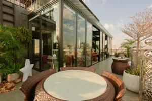 a glass building with a table and chairs on a patio at X-Digital HOTEL in Bắc Ninh
