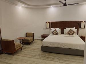 una camera da letto con un letto, un tavolo e una sedia di Hotel Crossway a Chennai
