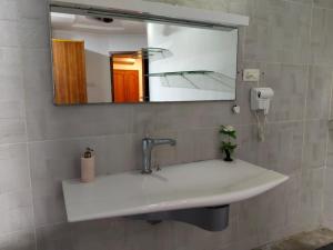 un lavandino in bagno con specchio di Hotel Crossway a Chennai