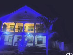 ein weißes Haus mit blauem Licht in der Nacht in der Unterkunft White House -Two palms in Kampala