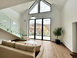 a living room with a couch and a large window at JAD Emirage Luxury Villa Infinity Pool and Spa in Bran