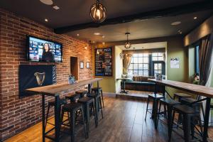 a bar with bar stools and a brick wall at The Station Restaurant & Bar in Doncaster