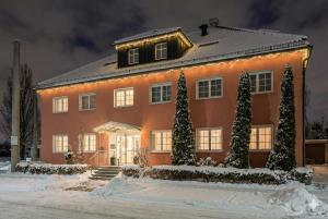 a house with christmas trees in front of it at Salzburg Hotel Lilienhof in Salzburg