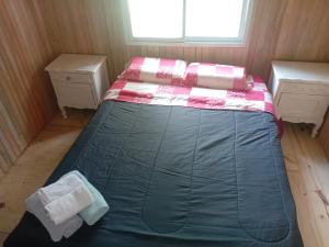 een bed in een kamer met twee ladekasten en een raam bij Soleada delta in Estación Delta