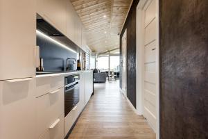 a kitchen with white cabinets and a long hallway at Hundweiler Hofheimat in Markdorf +15 photos