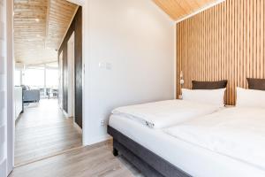 two beds in a room with white walls and wooden floors at Hundweiler Hofheimat in Markdorf