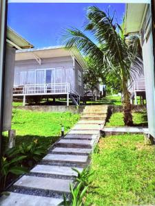 un camino que conduce a una casa con una palmera en kohrong sweet beach bungalows, en Koh Rong