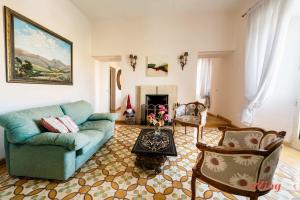 een woonkamer met een blauwe bank en stoelen bij Stunning Holiday Home with Gorgeous Harbour Views in Senglea +21 foto's