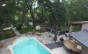 an overhead view of a swimming pool with a man sitting next to it at Gîte du Jonquas in Velleron +7 photos