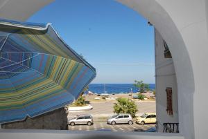 a colorful umbrella next to a parking lot with cars at Cannella studio flat Canneto Lipari in Canneto - Lipari +3 photos