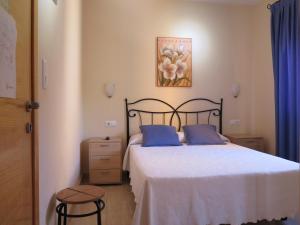 a bedroom with a bed with two blue pillows at Pensión La Venta in Puerto de Mazarrón