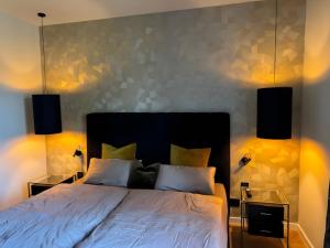 a bedroom with a bed with two night stands and two lamps at Zeitloser Luxus am Wasserschloss in Neukirchen