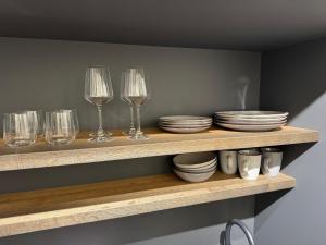 a shelf with wine glasses and plates and bowls at Zeitloser Luxus am Wasserschloss in Neukirchen +8 photos