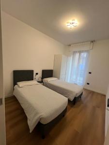 a room with two beds and a window at Black Swan Apartment in Peschiera del Garda