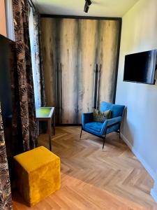 a living room with a blue chair and a table at Zeitloser Luxus am Wasserschloss in Neukirchen