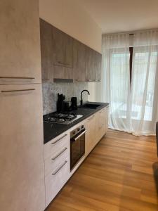 a kitchen with white cabinets and a stove top oven at Black Swan Apartment in Peschiera del Garda