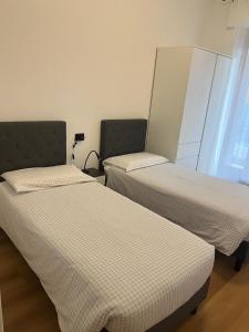 two twin beds in a room with a window at Black Swan Apartment in Peschiera del Garda