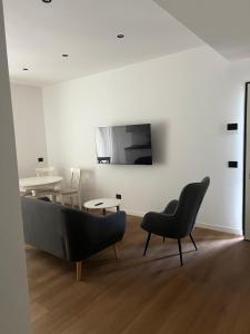 a living room with two chairs and a couch at Black Swan Apartment in Peschiera del Garda