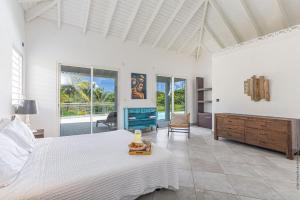 Oyster PondVilla Taïana的卧室里有一张白色的床和一扇大窗户 更多76张照片