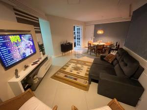 salon z kanapą i telewizorem w obiekcie Melhor Apto no Centro ao lado da Praia e Comércio w mieście Guarapari