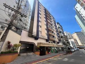 wysoki budynek przy ulicy miejskiej z w obiekcie Melhor Apto no Centro ao lado da Praia e Comércio w mieście Guarapari