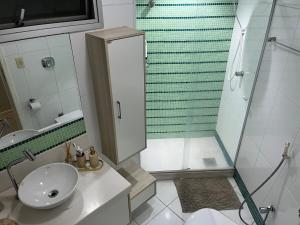 biała łazienka z prysznicem i umywalką w obiekcie Melhor Apto no Centro ao lado da Praia e Comércio w mieście Guarapari +12 zdjęć