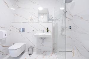 a bathroom with a toilet and a sink and a shower at Kikelet Club Hotel in Miskolctapolca +88 photos
