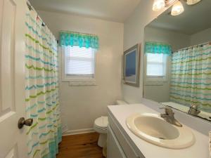 ein Badezimmer mit Waschbecken, Toilette und Spiegel in der Unterkunft Petty House in Edisto Island + 30 Fotos