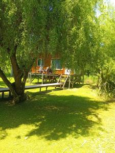een huis met een boom en een houten hek bij Soleada delta in Estación Delta