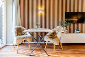 een eetkamer met 2 stoelen en een tafel bij Riff5 Wohnung 1 in Borkum