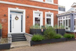 una casa di mattoni con una porta bianca e una corona di Pier17 Appartement 1 a Borkum