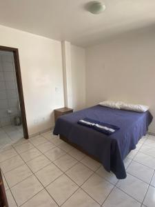 ein Schlafzimmer mit einem Bett und einem gefliesten Boden in der Unterkunft Hotel Menegatti in Pato Branco